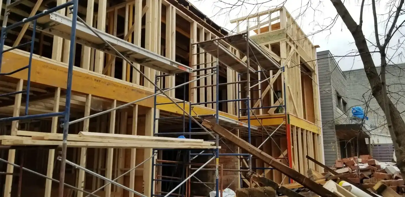 Ossature de bois d’un agrandissement de deux étages montée contre une maison existante