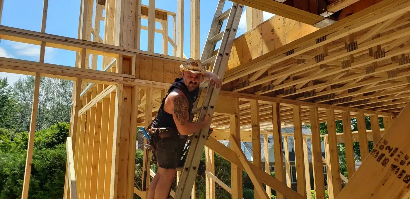Maxime Roy Bouliane devant une ossature de bois montée sur un chantier