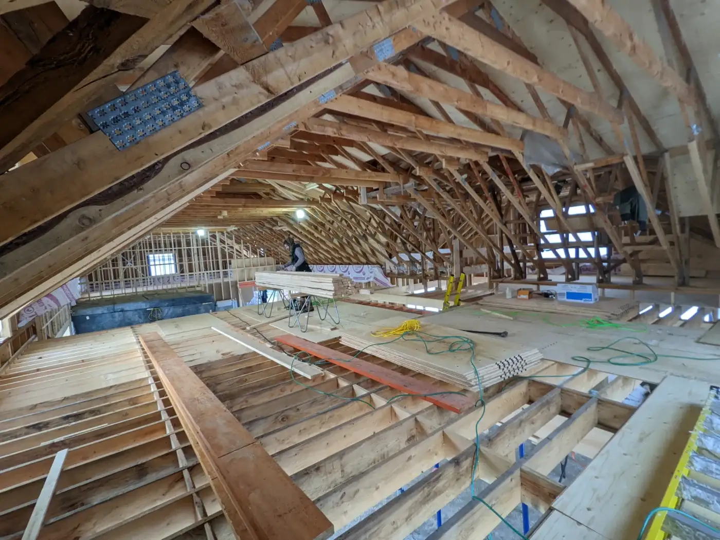 Grand comble de grange ancienne où des fermes de bois neuves ont été mariées aux fermes d'origine