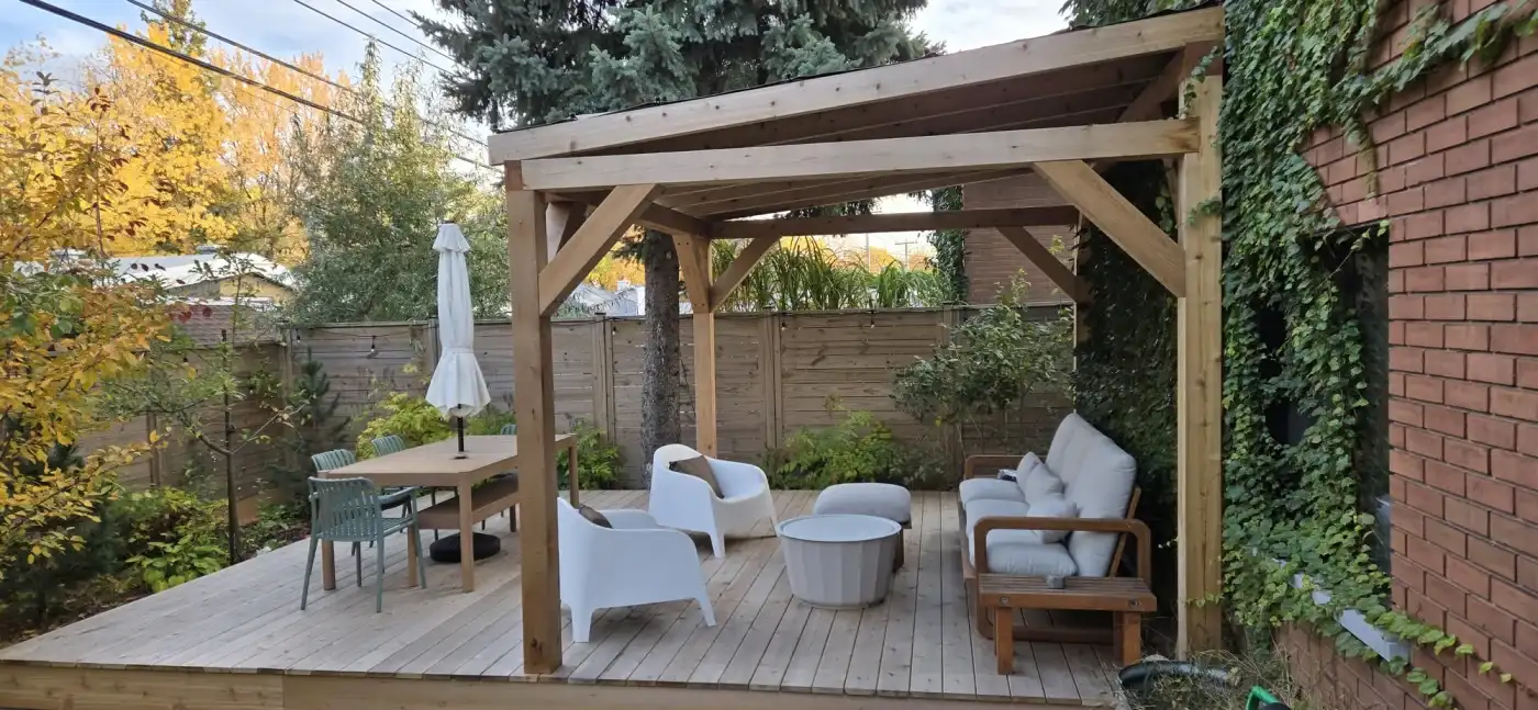 Pavillon de cèdre avec son plancher de bois et son mobilier, monté au fond d'une cour