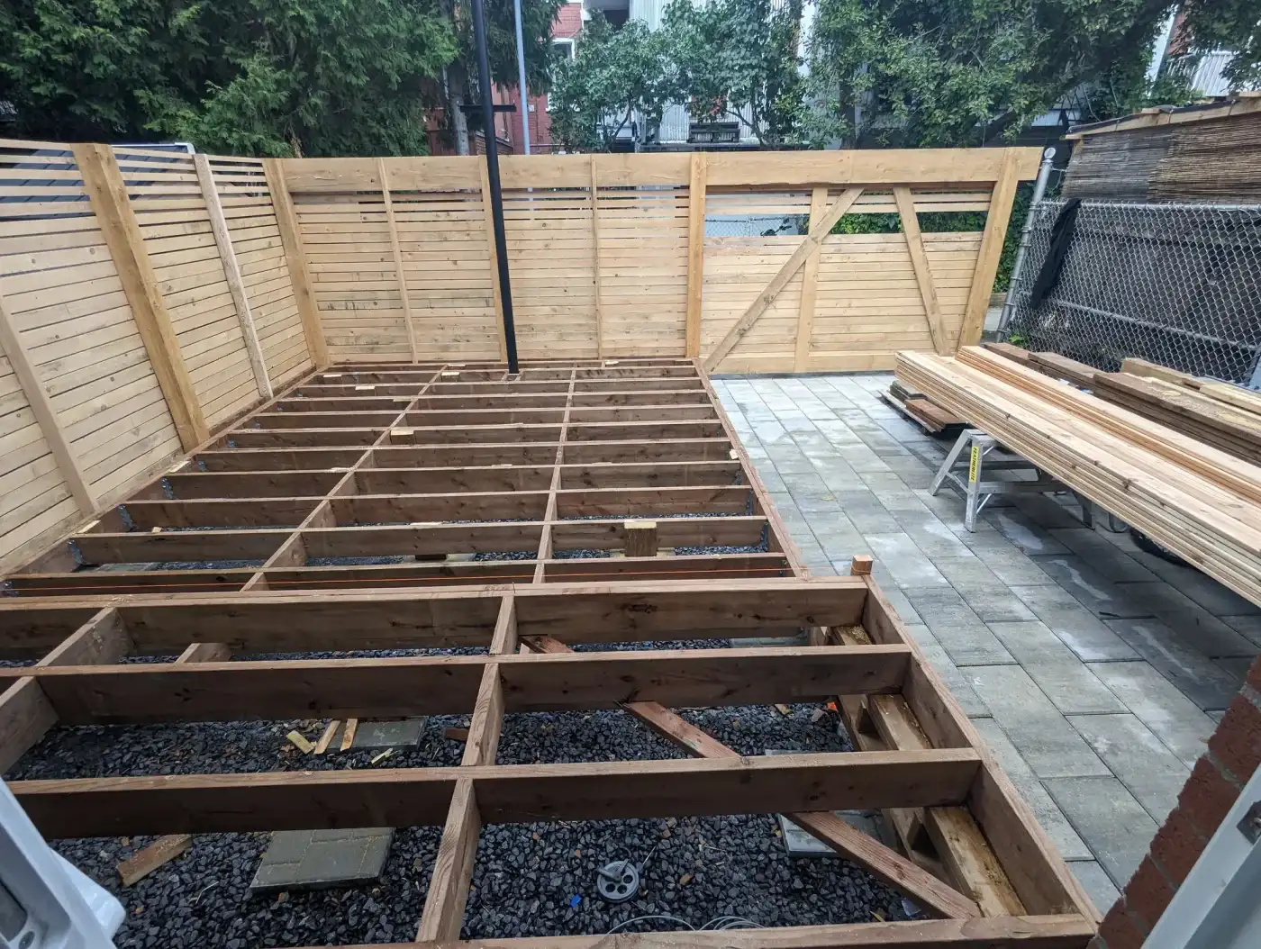 Solivage de terrasse posé sur assises de pierre, écrans en cours de montage